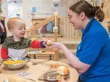 A nursery worker playing with a toddler at Barton Moss Nursery