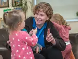 A nursery worker playing with some children at Barton Moss Nursery