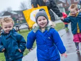 Some children playing outside on a wet day at Barton Moss Nursery