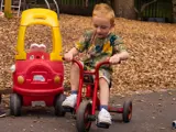 A young boy on a trike outside