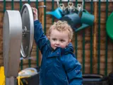 A toddler playing outside at Barton Moss Nursery