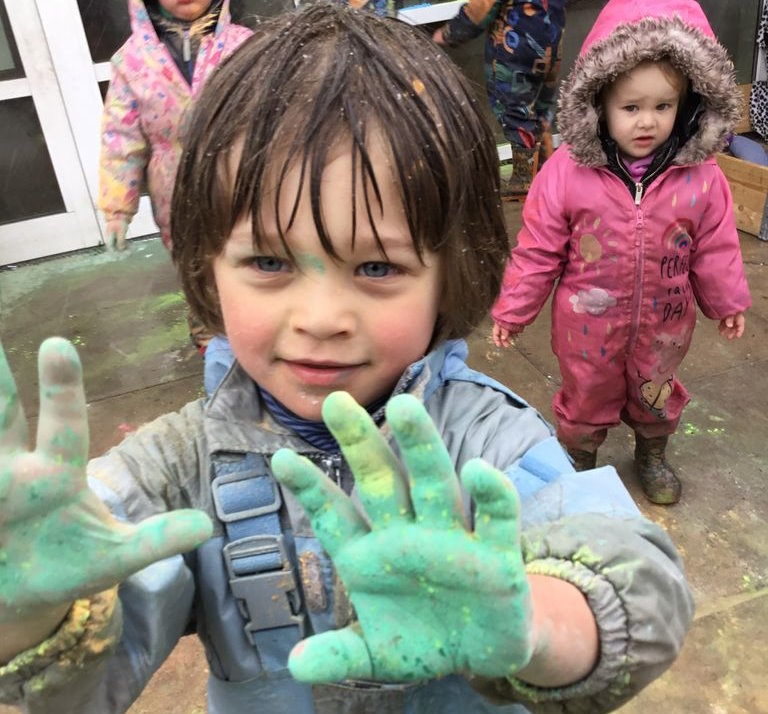 A young boy with green hands