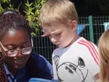 A nursery worker playing with a boy and a girl