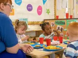 A nursery worker playing with some children at Little Hulton Nursery