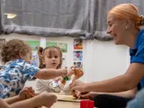 A nursery worker playing with some children at Little Hulton Nursery