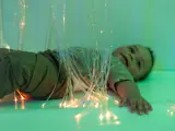 A toddler lying down in the sensory room at Higher Broughton Nursery