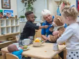 A boy and a girl playing with a nursery worker at Barton Moss Nursery