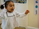 A toddler playing with bubbles  inside Belvedere nursery
